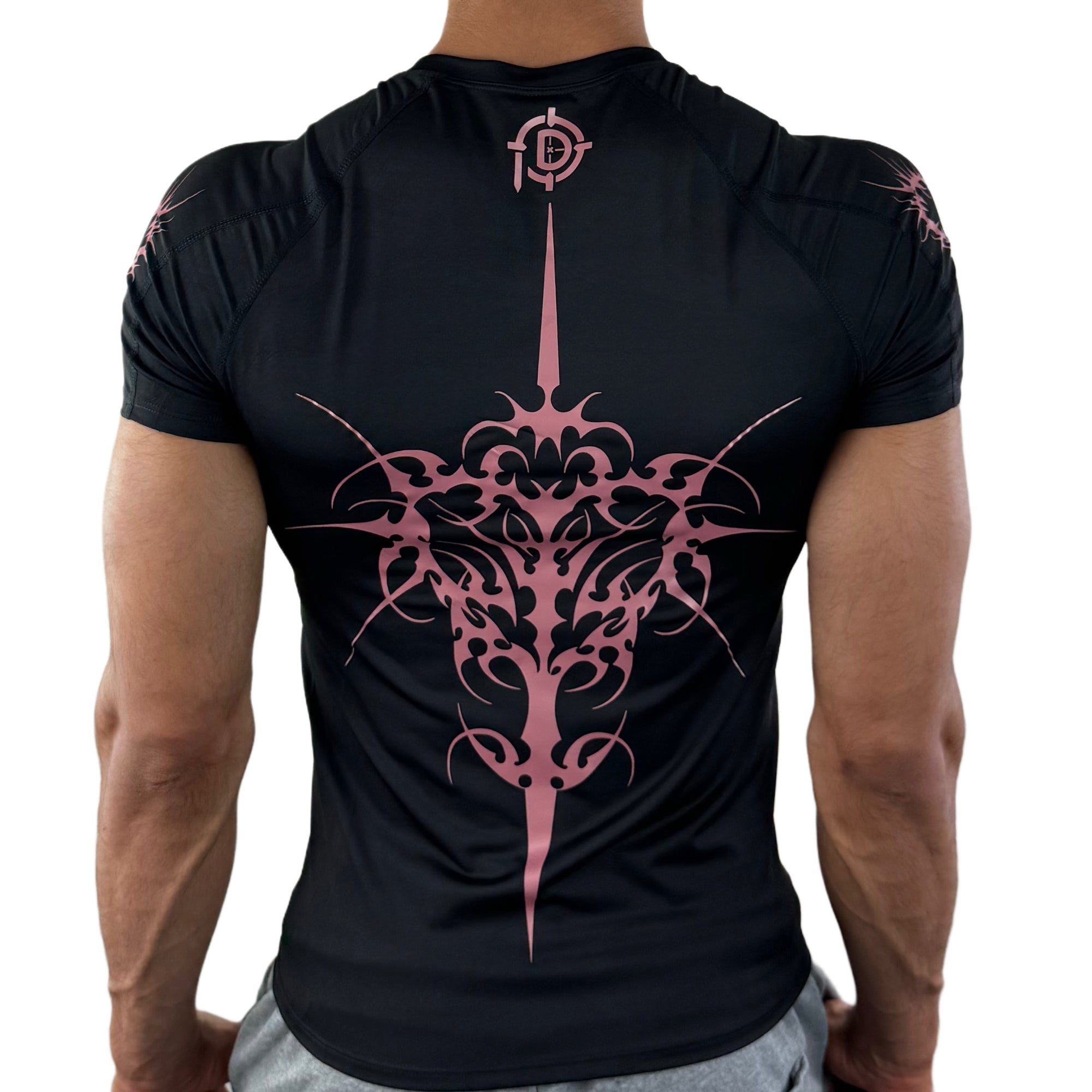 Man wearing black compression shirt with large pink symmetrical tribal design on back and Pludyna logo at neck