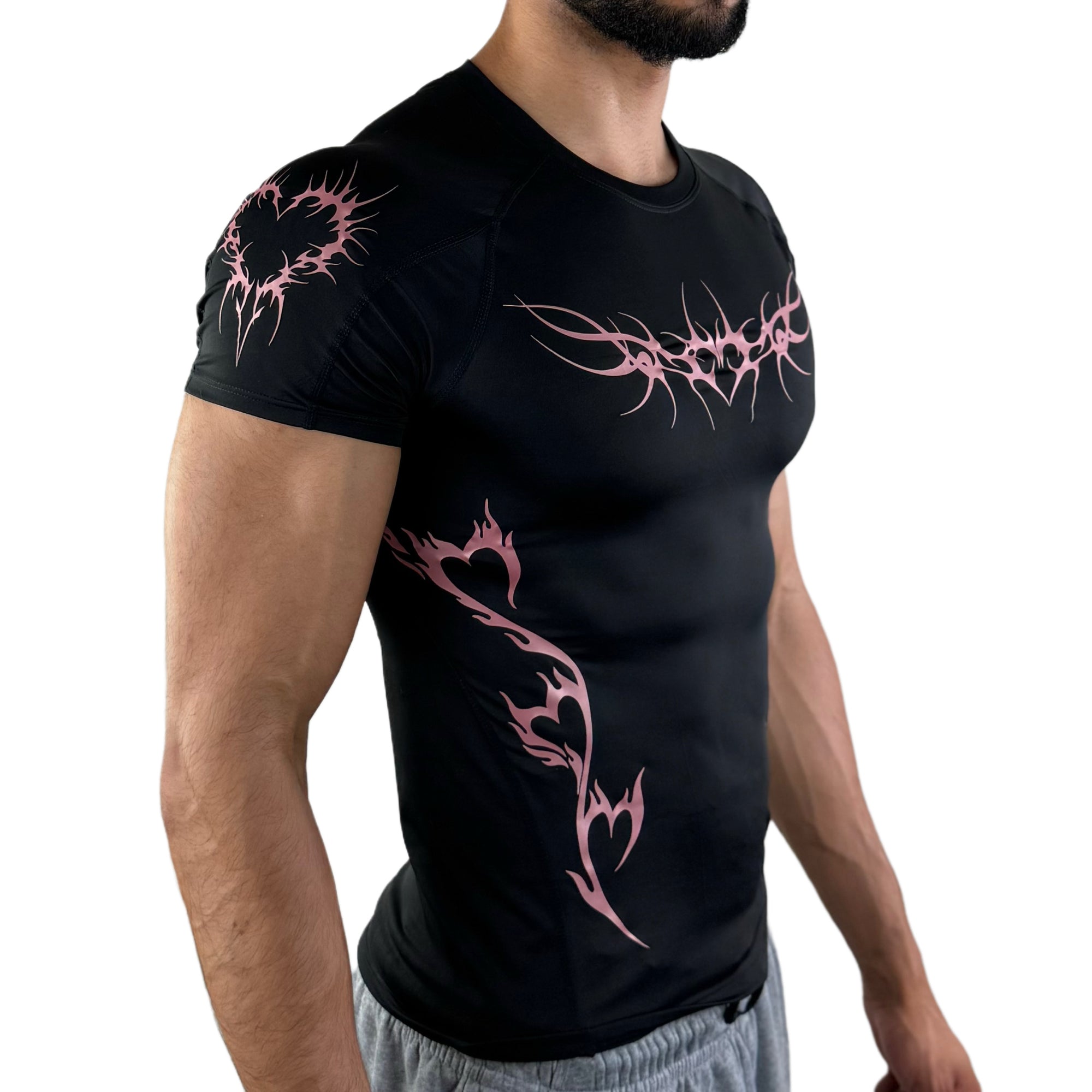 Close-up side view of black athletic shirt with pink flaming heart graphics and tribal chest design