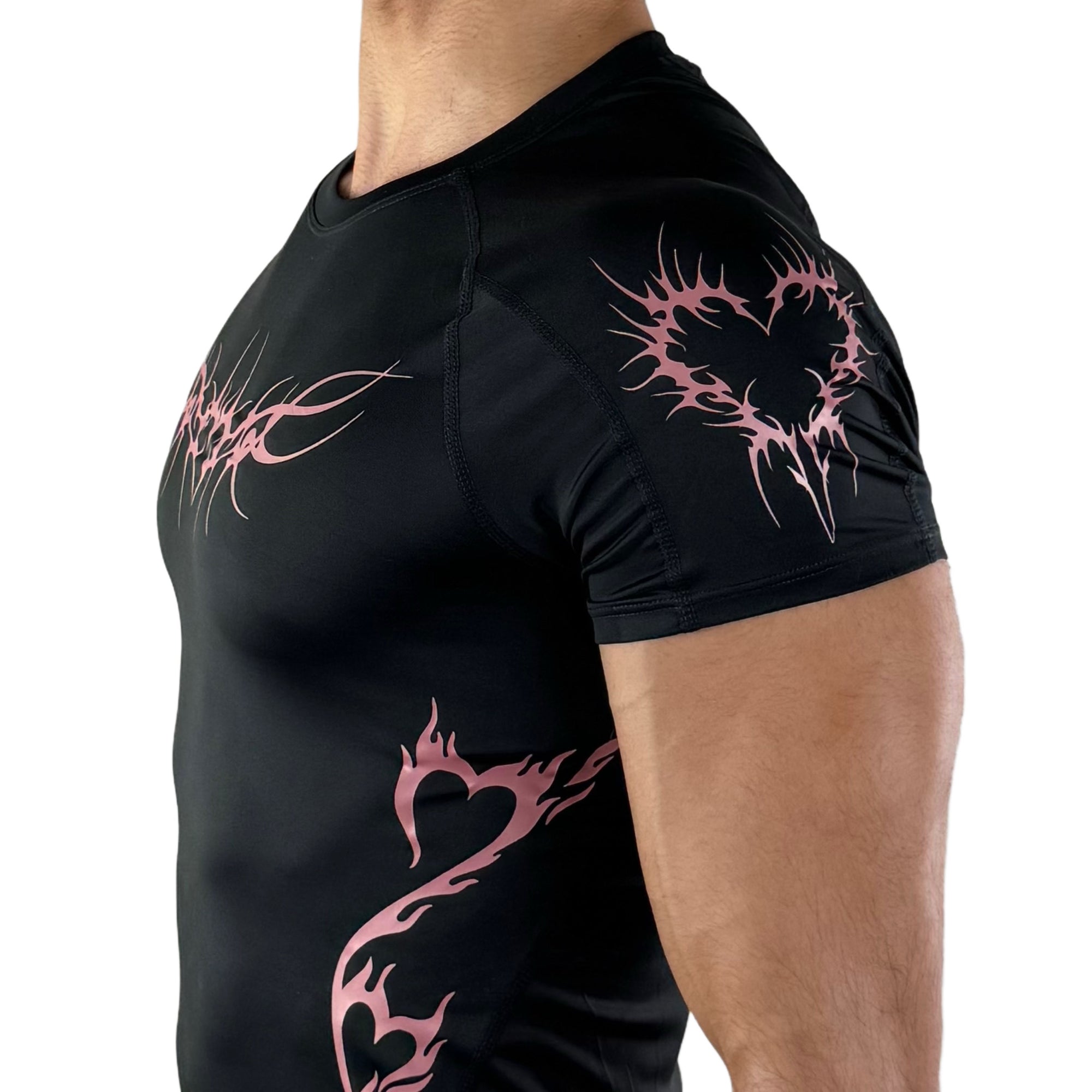 Detailed view of sleeve on black compression shirt featuring pink flame heart graphic