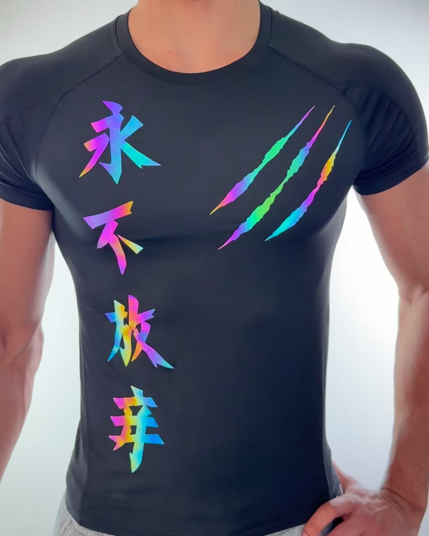 Video of a man wearing a black compression shirt with vibrant reflective Chinese characters and claw mark design glowing under bright light